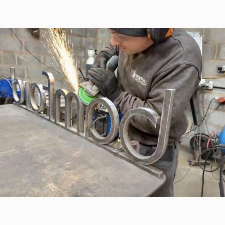 Metal fabrication Worcestershire. Hand finishing custom metal signage for Bamford's RHS Chelsea trade stand. Steel fabricator