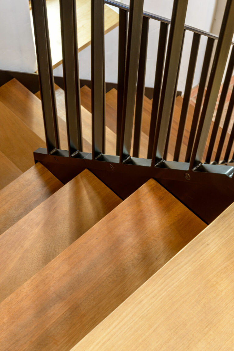 Close-up of a modern steel staircase featuring timber treads designed by Winthill Engineering for 18th century barn conversion in Shropshire