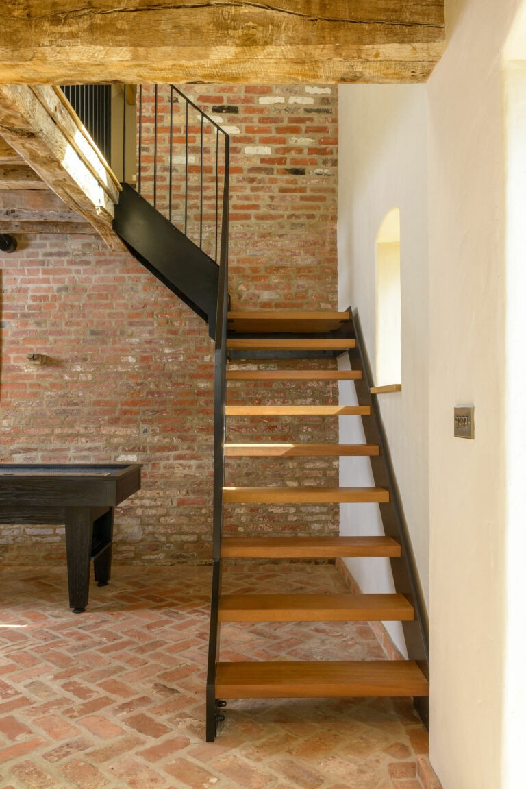 Custom steel and timber floating staircase installed along the exterior wall of an 18th-century Georgian barn conversion in West Midlands